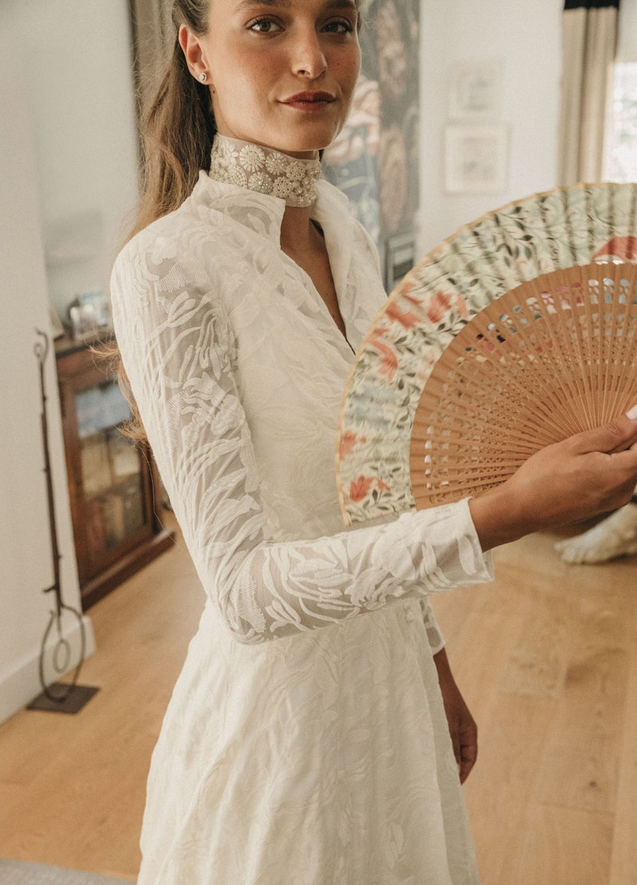 Vestido de novia de encaje y cuello alto con abanico