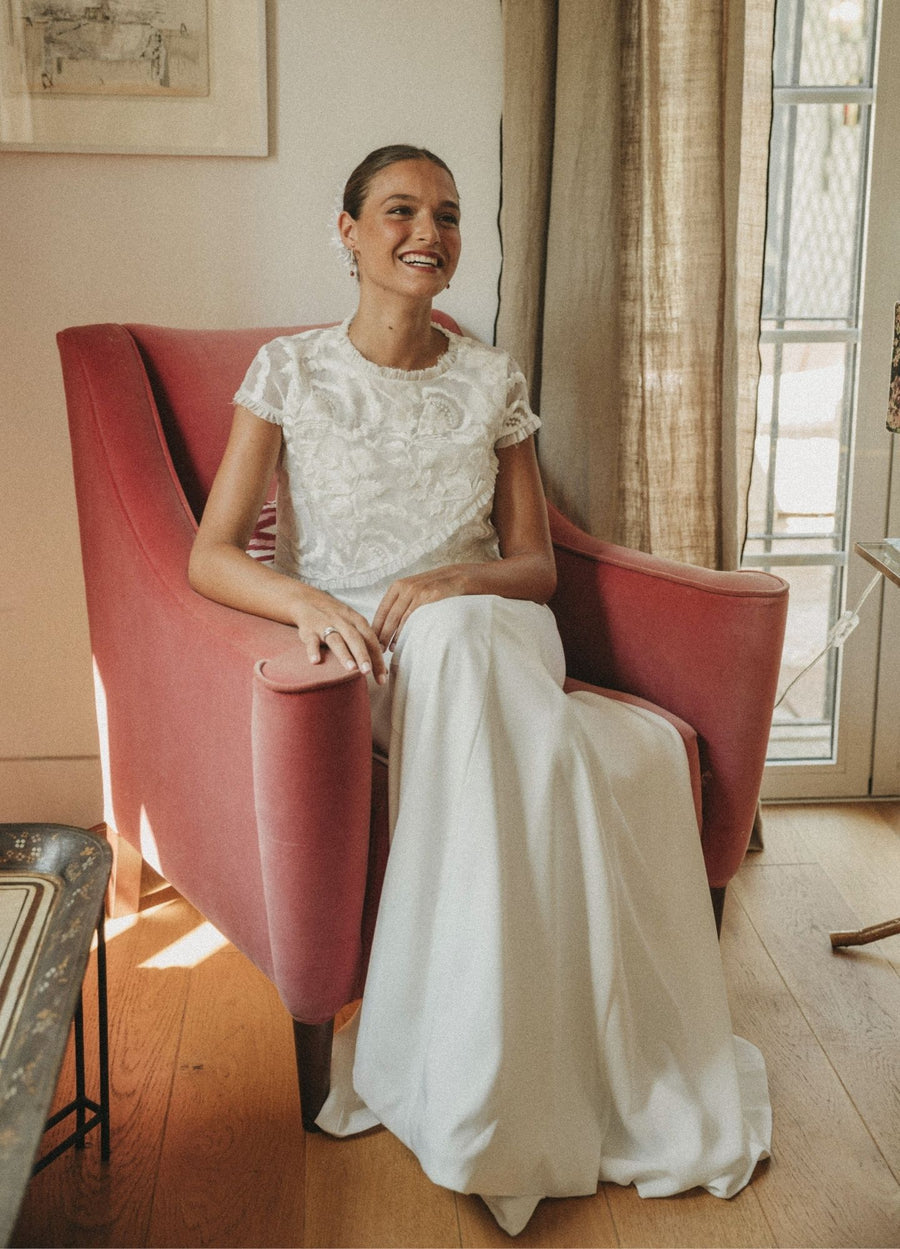 Novia sonriente con vestido de dos piezas y encaje