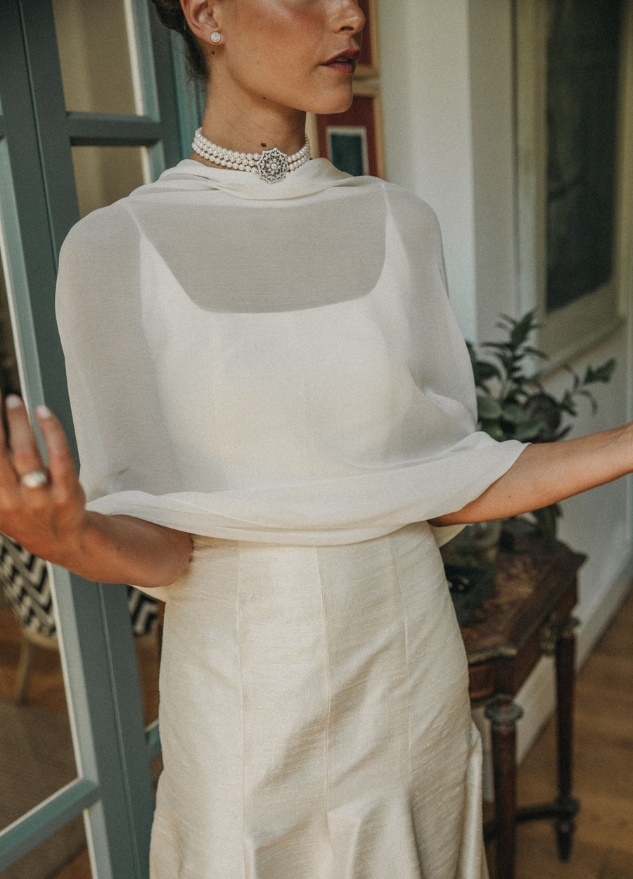 Detalle de capa de gasa y collar de perlas en vestido de novia