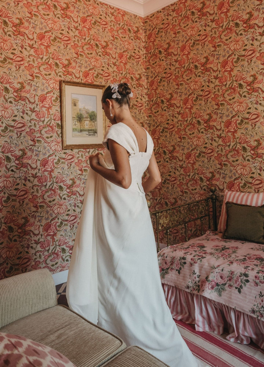Vestido de novia con espalda escotada y manga capa