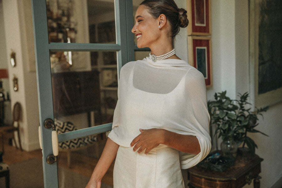 Novia con capa de gasa y collar de perlas